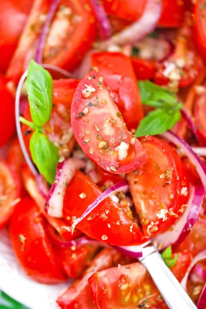close shot of italian tomato salad with a serving spoon