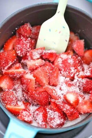 cooking strawberries and sugar in a saucepan