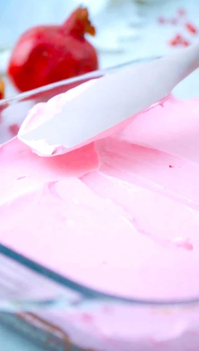 spreading pomegranate mousse layer with a spatula