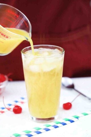 adding orange juice to a cocktail