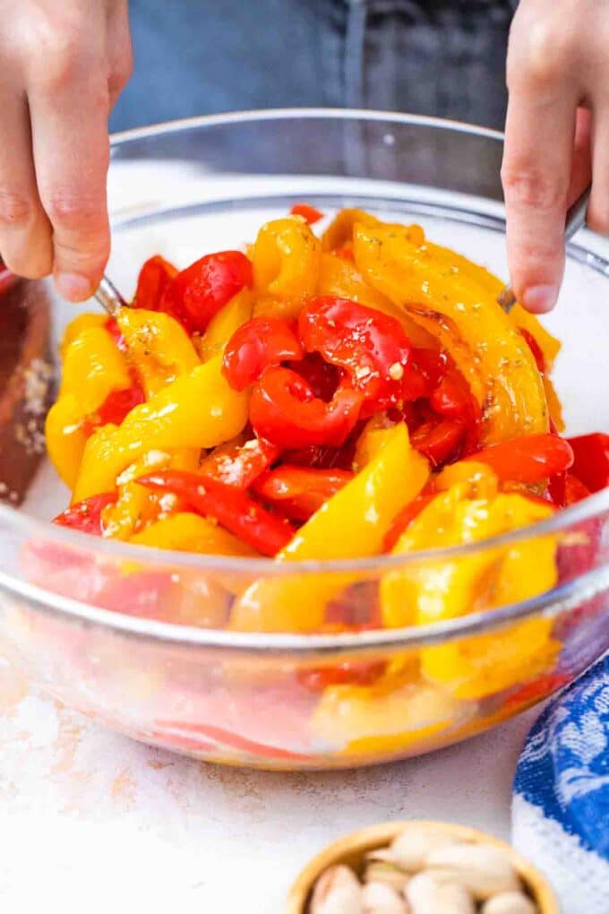 mixing sliced roasted bell peppers
