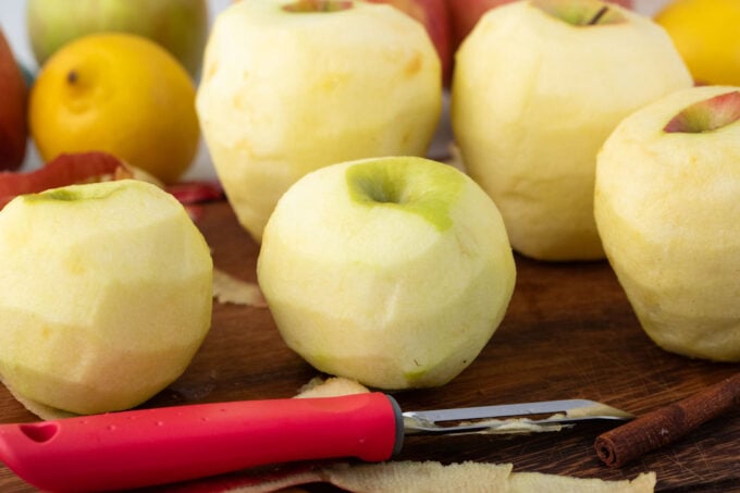 Peeled apples on a cutting board.