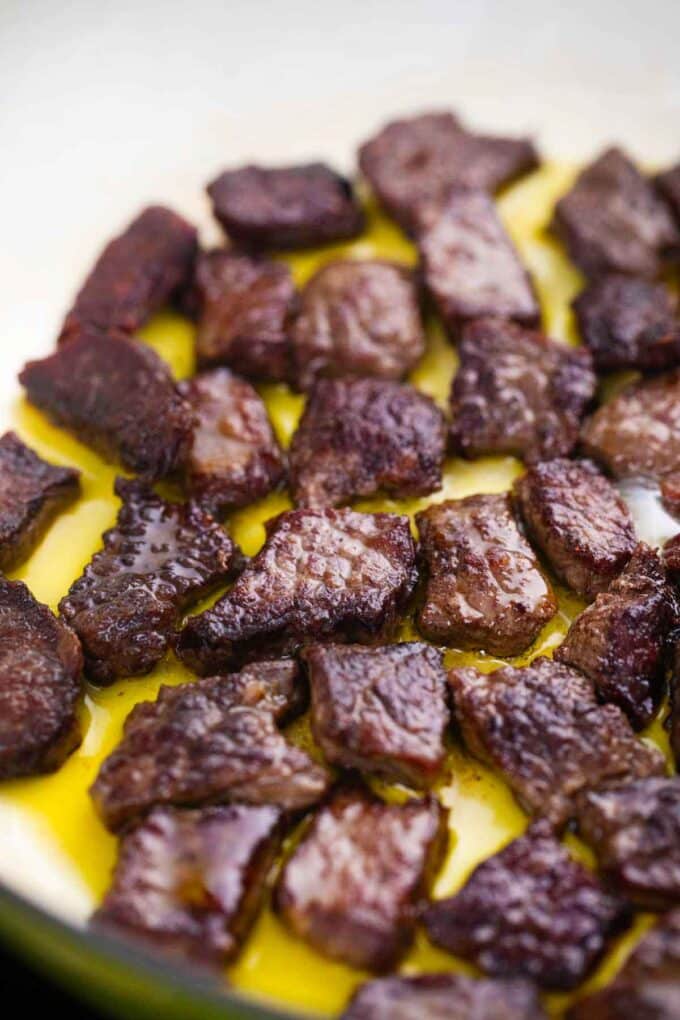 browning steak pieces in a skillet