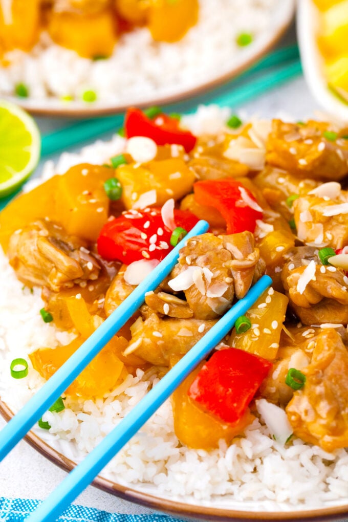 Holding pieces of slow cooker Hawaiian chicken with chopsticks.