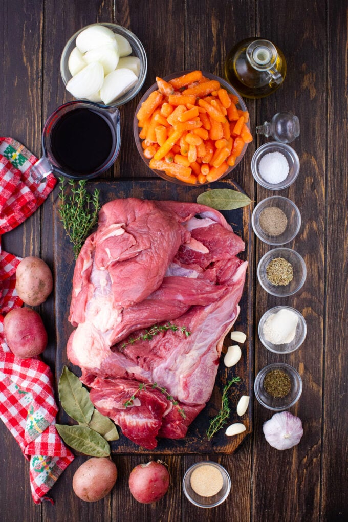 overhead shot of red wine slow cooker pot roast ingredients on a wooden table.