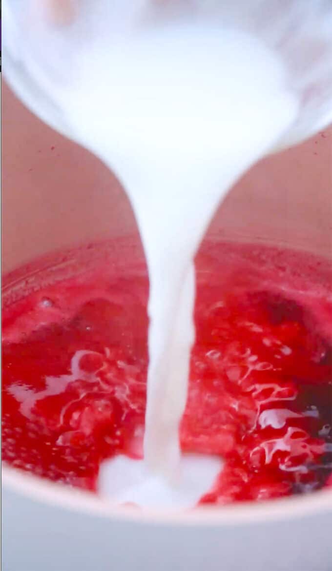 adding cornstarch slurry to simmered pomegranate juice