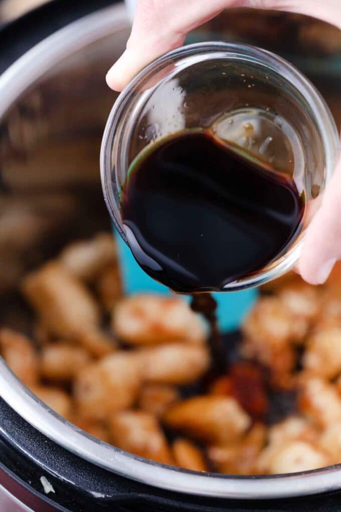 pouring soy sauce on top of chicken in the instant pot