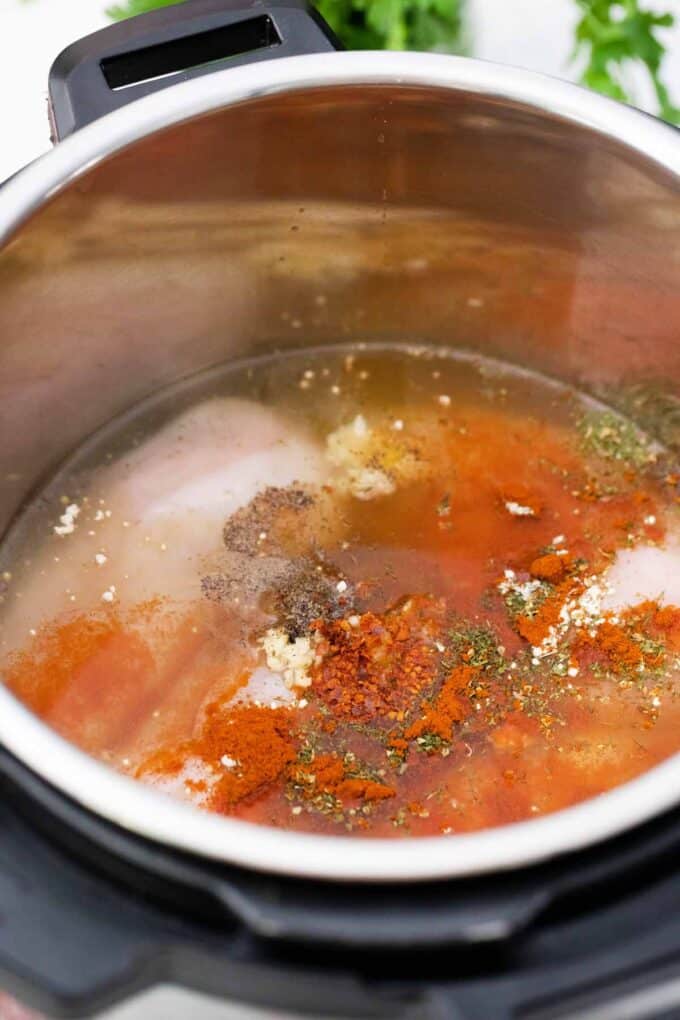 Chicken, liquid and spices in the instant pot.