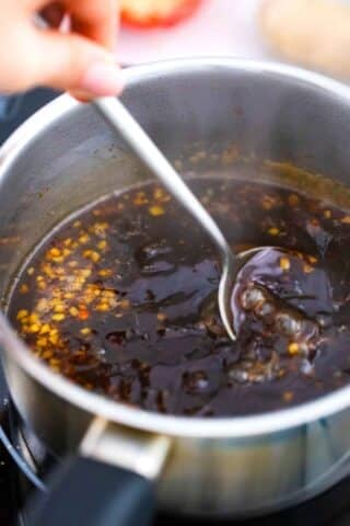 stirring general tso sauce in a saucepan