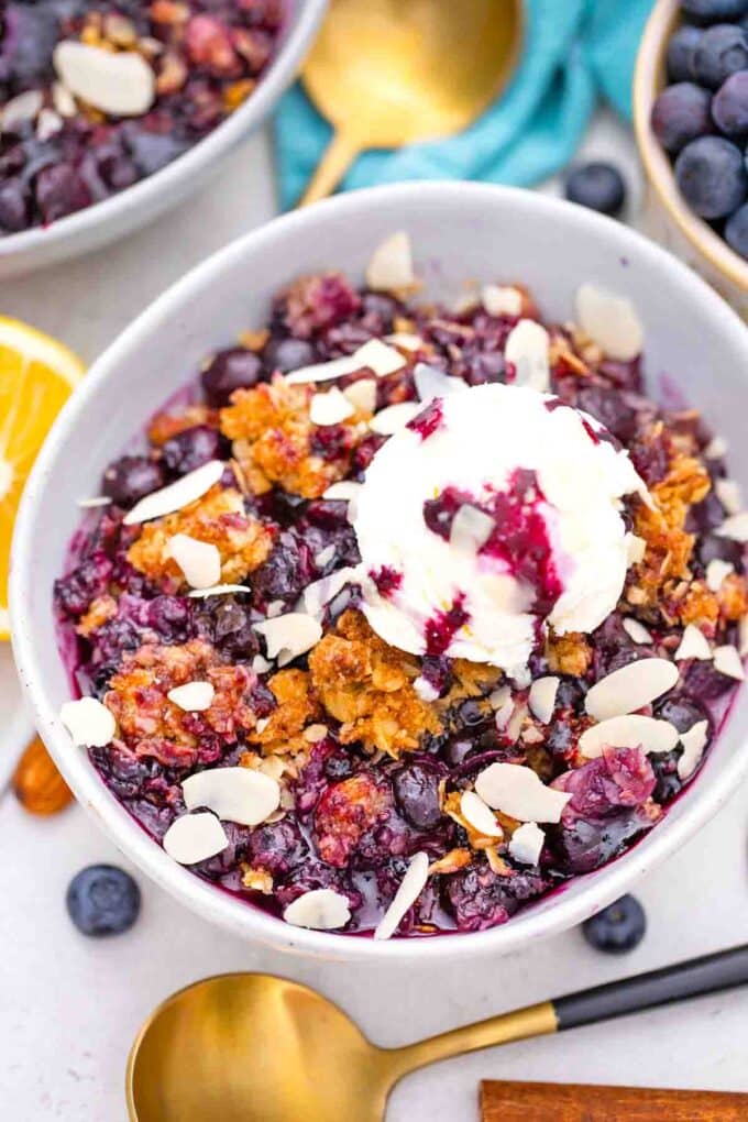 a bowl of blueberry crisp with ice cream