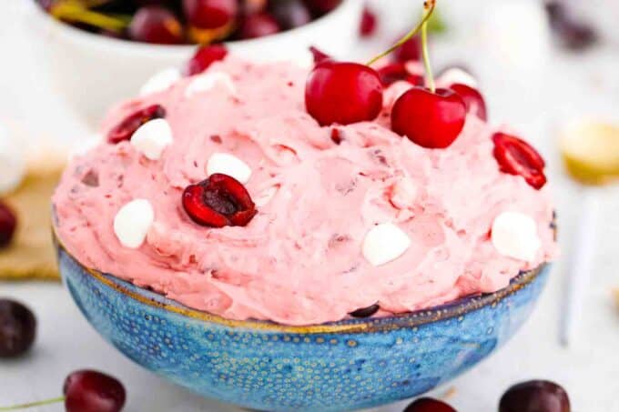 cherry cheesecake fluff in a bowl topped with fresh cherries
