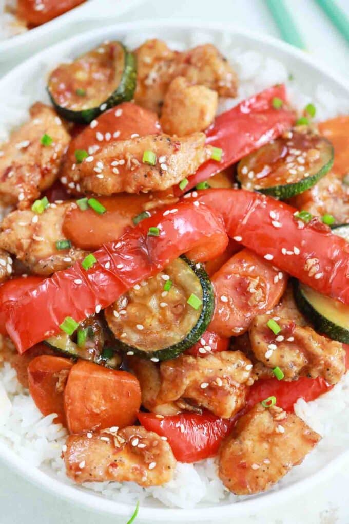 classic hunan chicken with belle peppers and zucchini served on top of rice