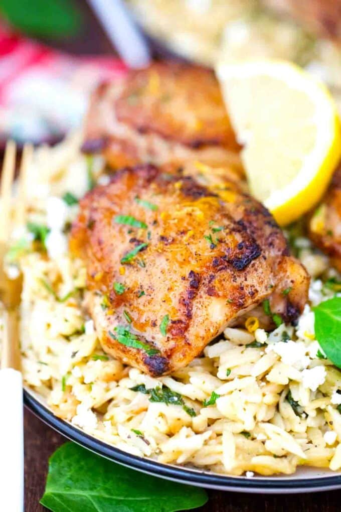 one pan chicken and orzo on a serving plate with lemon on the side