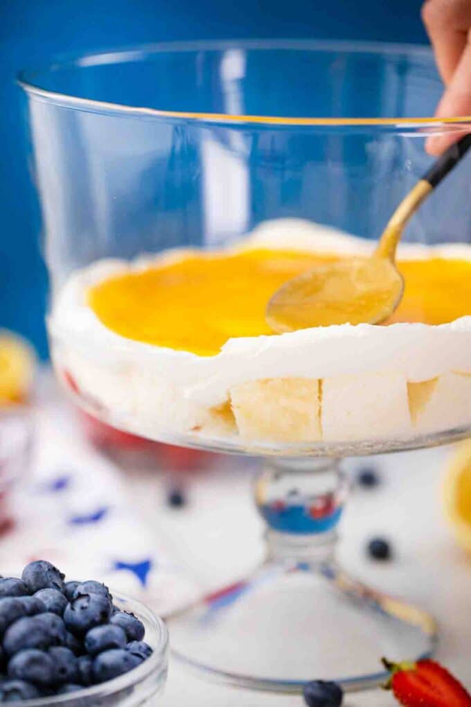adding a layer of lemon curd for trifle