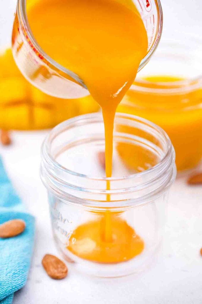pouring mango puree into a mason jar
