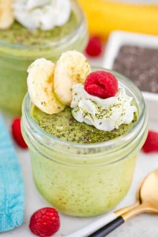 matcha chia pudding in a jar topped with whipped cream and bananas