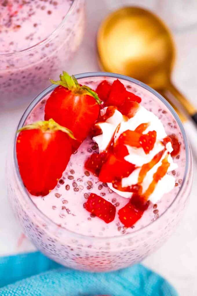 overhead shot of a glass with strawberry chia pudding topped with strawberries