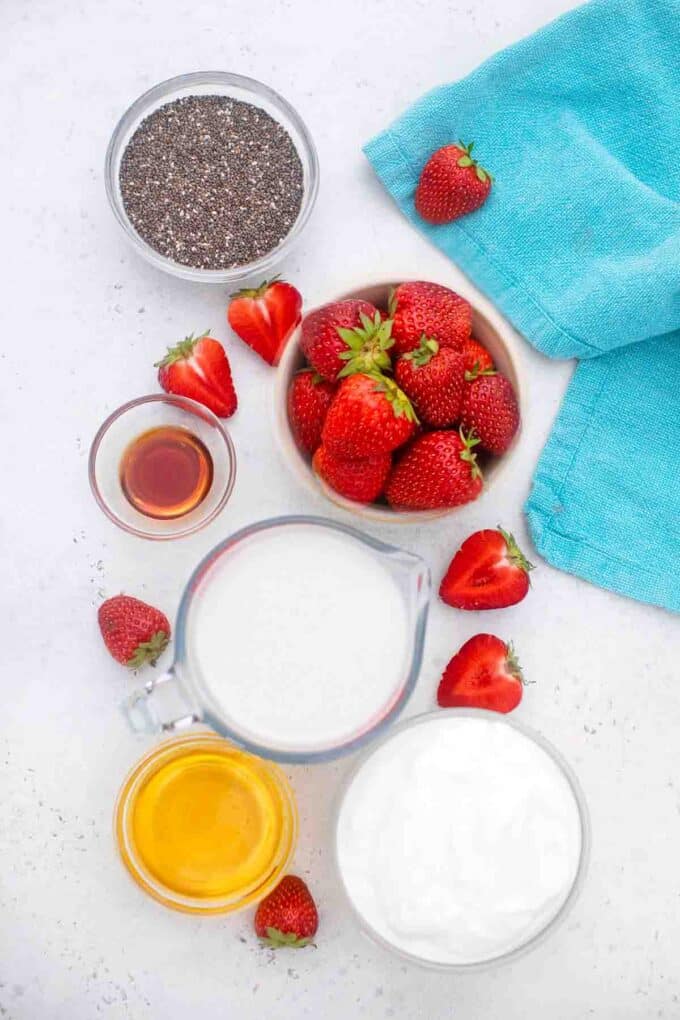 overhead shot of strawberry chia pudding ingredients in bowls on a table