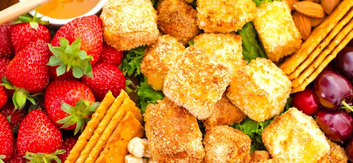 overhead shot of air fried brie platter with honey buts and berries