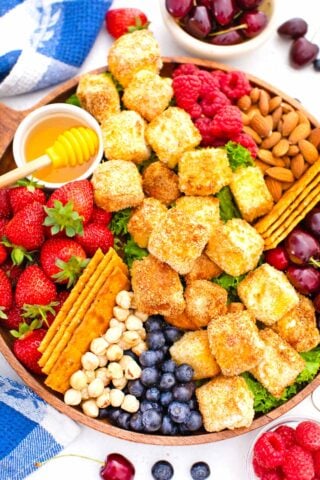 overhead shot of air fried brie platter with honey buts and berries