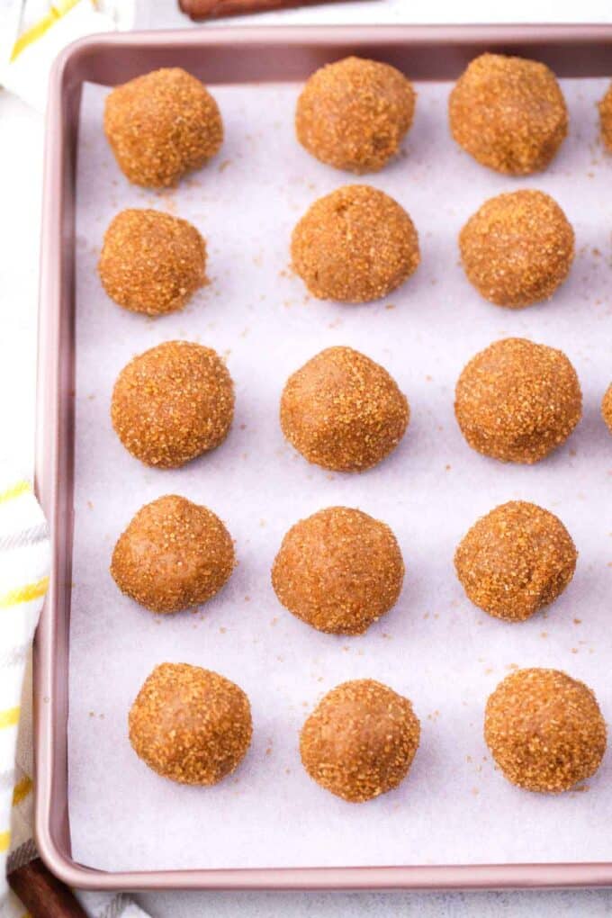 molasses cookie dough balls arranged on a baking sheet