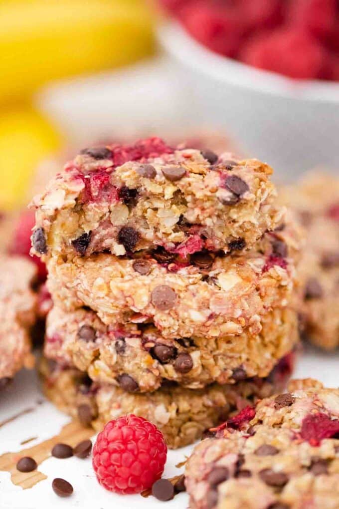 healthy oatmeal raspberry cookies stacked and half a cookie on top
