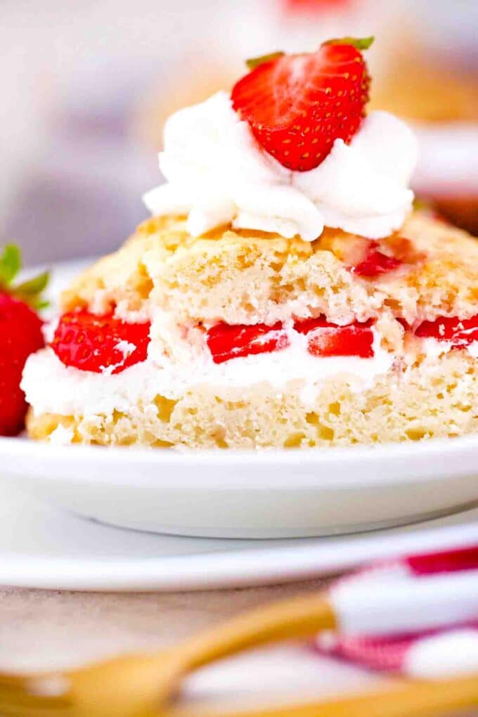 strawberry shortcake cut in half revealing whipped cream and strawberry filling