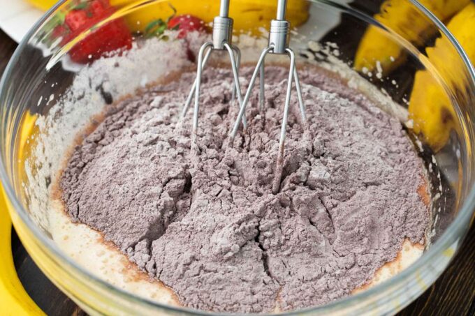 Mixing dry ingredients with wet ingredients in a bowl.