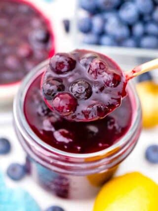 overhead shot of a spoonful of blueberry pie filling on top of a mason jar