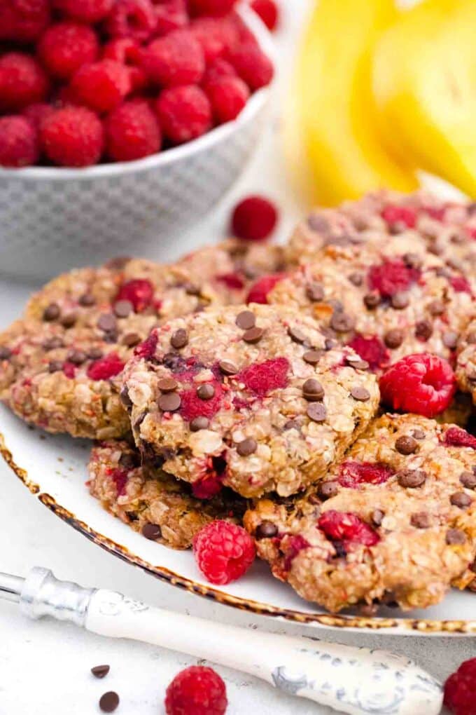 a plate with healthy raspberry cookies with chocolate chips and fresh raspberries