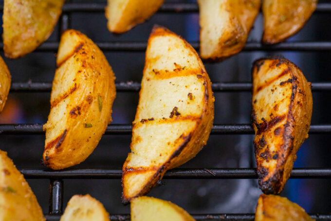 Grilling potato wedges.