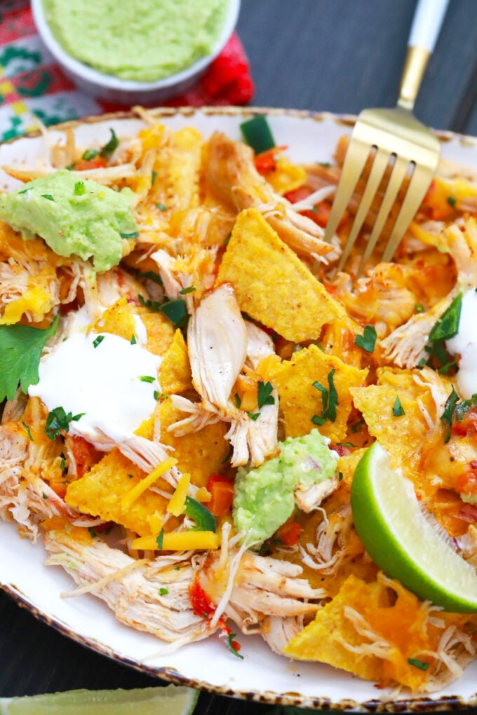 Deconstructed Instant Pot chicken nachos served with a lime wedge.