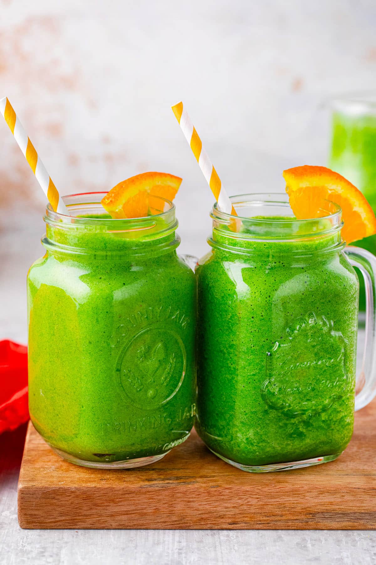 Green spinach smoothie served with oranges.