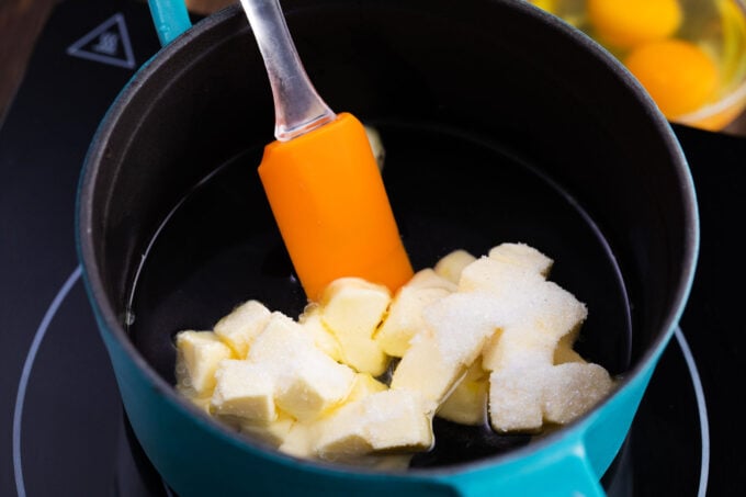 Melting butter, sugar, and water in a saucepan.