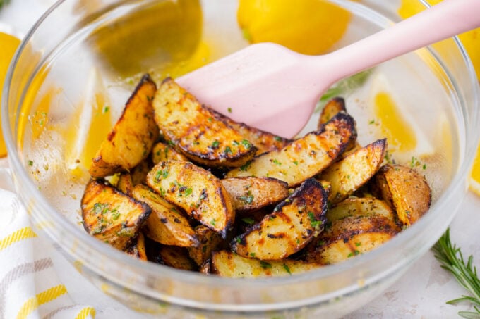 Tossing grilled potatoes into parsley lemon sauce.