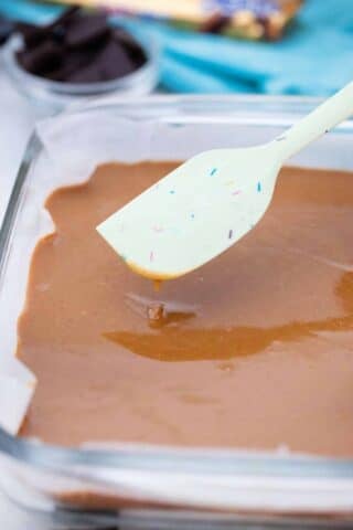 smoothing a peanut butter layer in a baking dish