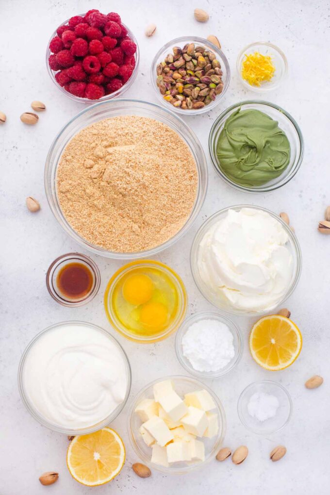 overhead shot of pistachio cheesecake ingredients in bowls on a table