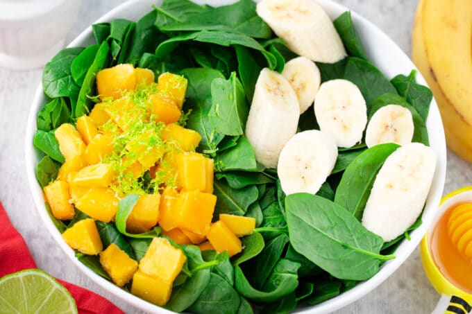 Overhead shot of spinach smoothie ingredients in a bowl.