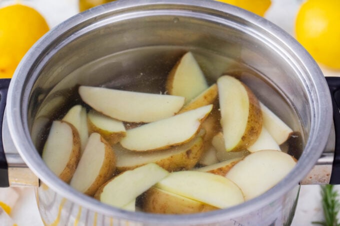 Parboiling potato wedges.