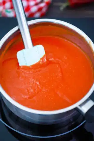 stirring enchilada sauce in a saucepan