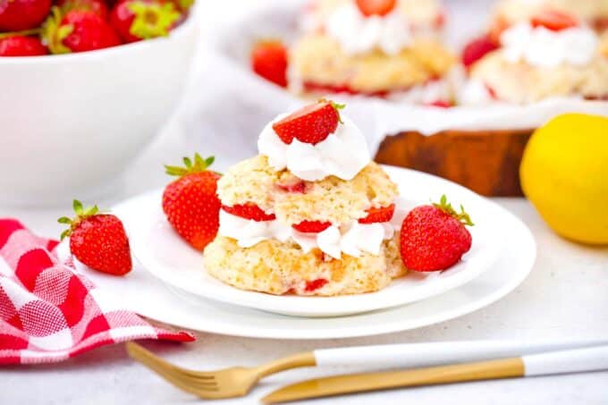strawberry shortcakes on a serving plate with fresh strawberries next to it