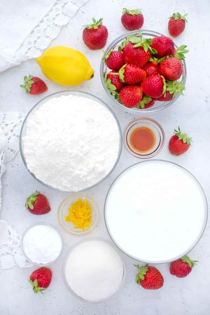 overhead shot of strawberry shortcakes ingredients in bowls on a table