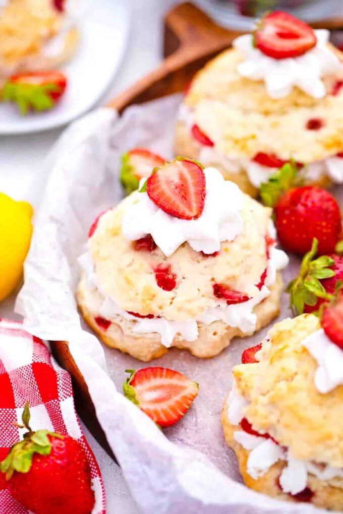 Overhead shot of the side of a wooden tray with strawberry shortcakes.