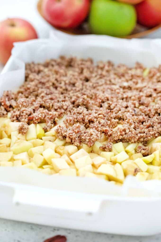 adding streusel topping on top of chopped apples
