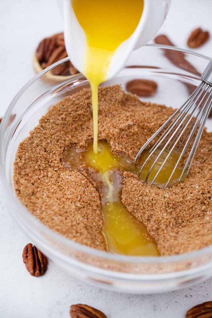 pouring butter over gingersnap cookie crumbs