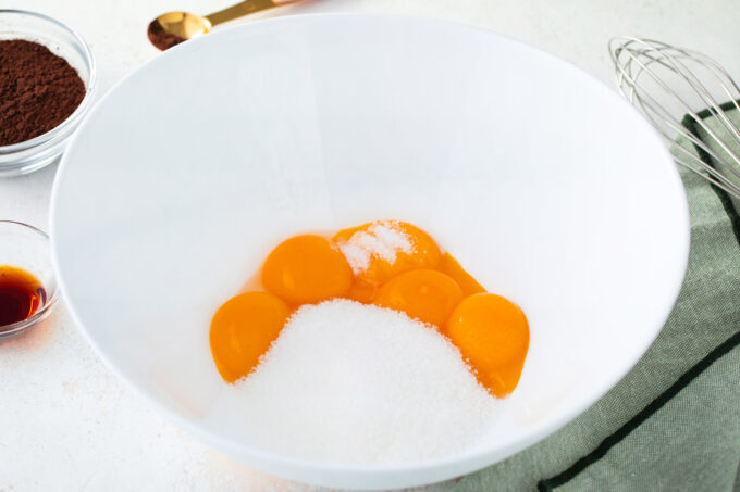 Egg yolks and sugar in a bowl.
