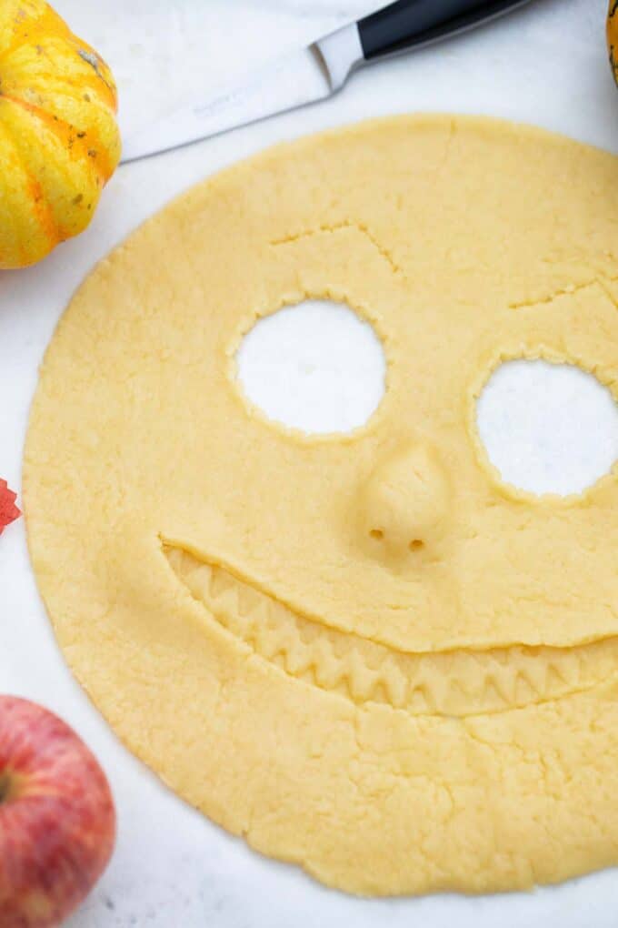 scary face cut into pie crust on a white table