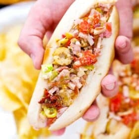 close shot of a man hand holding the holding viral chopped italian sandwich