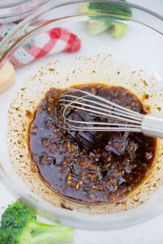 a whisk in a bowl with balsamic marinade
