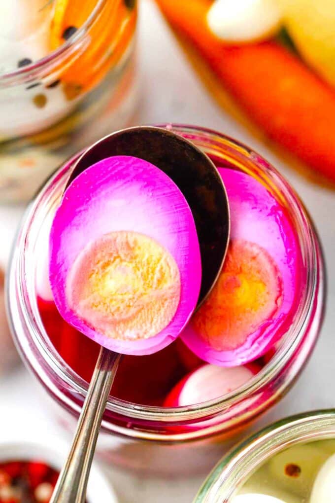 beet pickled egg cut in half on a spoon